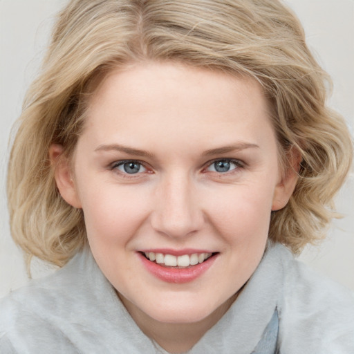 Joyful white young-adult female with medium  brown hair and blue eyes