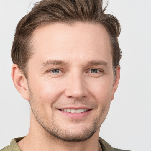 Joyful white young-adult male with short  brown hair and grey eyes