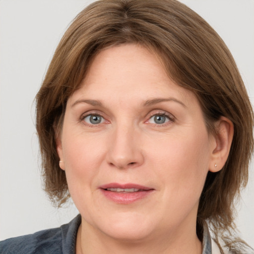 Joyful white adult female with medium  brown hair and grey eyes