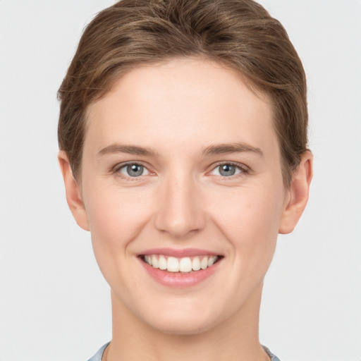 Joyful white young-adult female with short  brown hair and grey eyes