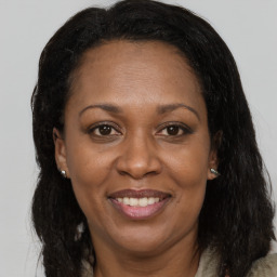 Joyful black adult female with long  brown hair and brown eyes