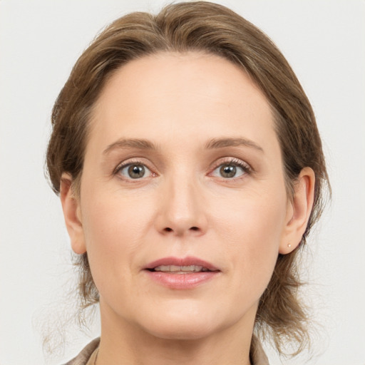 Joyful white adult female with medium  brown hair and grey eyes