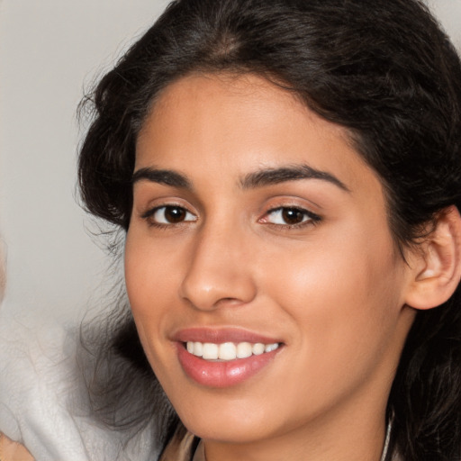 Joyful latino young-adult female with long  brown hair and brown eyes