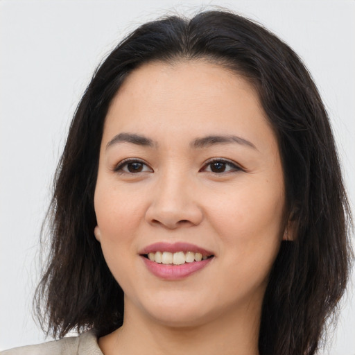 Joyful asian young-adult female with long  brown hair and brown eyes