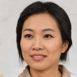 Joyful asian adult female with medium  brown hair and brown eyes