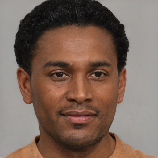 Joyful black young-adult male with short  black hair and brown eyes