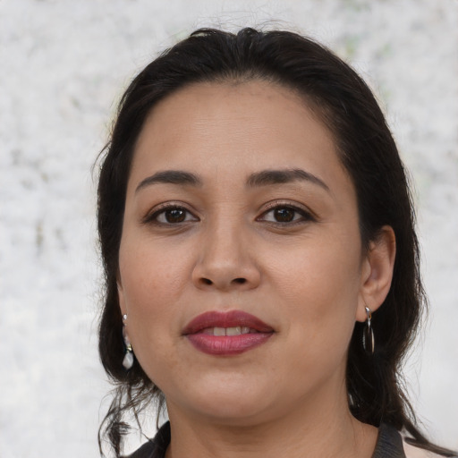 Joyful latino young-adult female with medium  brown hair and brown eyes