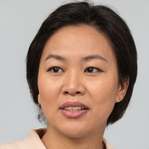 Joyful asian adult female with medium  brown hair and brown eyes