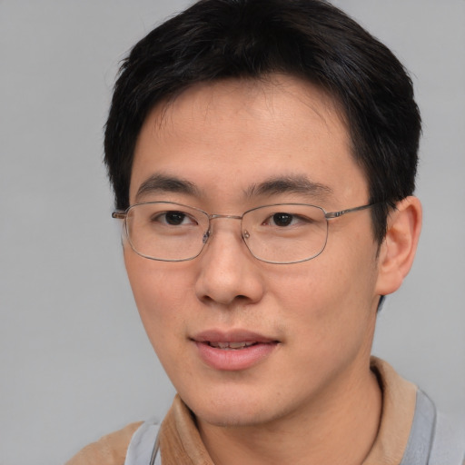 Joyful asian young-adult male with short  brown hair and brown eyes