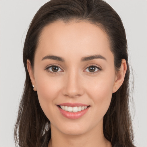 Joyful white young-adult female with long  brown hair and brown eyes