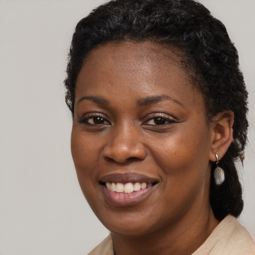 Joyful black young-adult female with short  black hair and brown eyes
