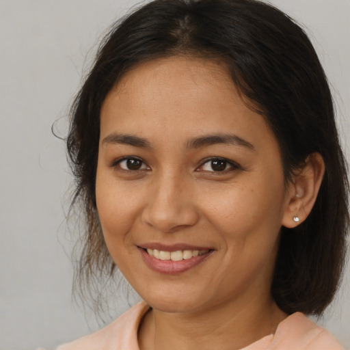 Joyful latino young-adult female with medium  brown hair and brown eyes