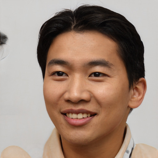 Joyful asian young-adult male with short  brown hair and brown eyes