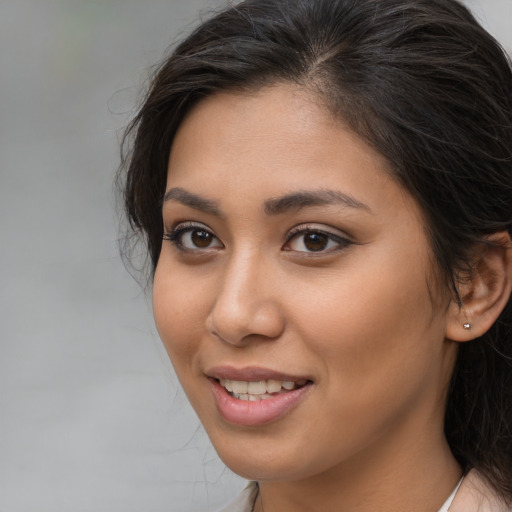 Joyful latino young-adult female with long  brown hair and brown eyes