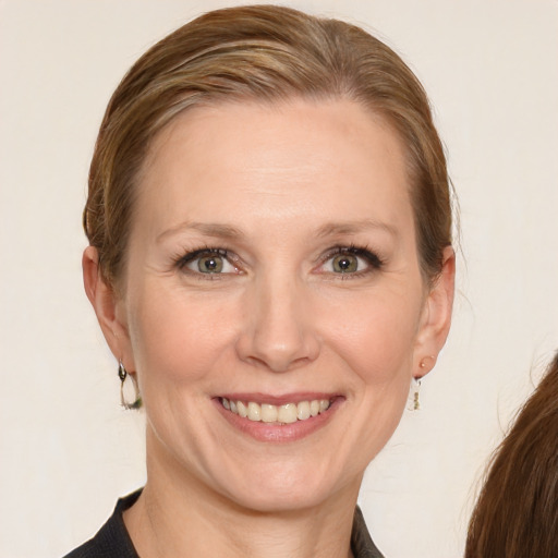 Joyful white adult female with medium  brown hair and blue eyes