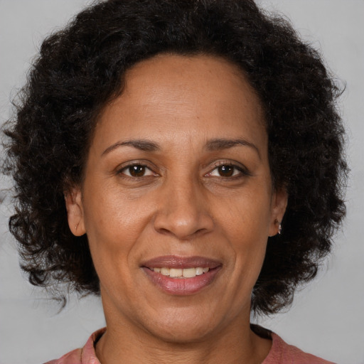 Joyful black adult female with medium  brown hair and brown eyes