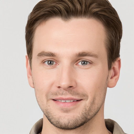 Joyful white young-adult male with short  brown hair and grey eyes