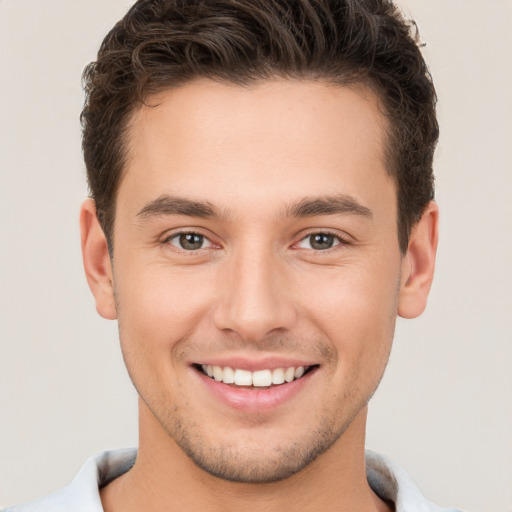 Joyful white young-adult male with short  brown hair and brown eyes