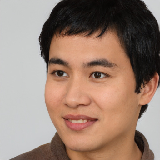 Joyful asian young-adult male with short  black hair and brown eyes