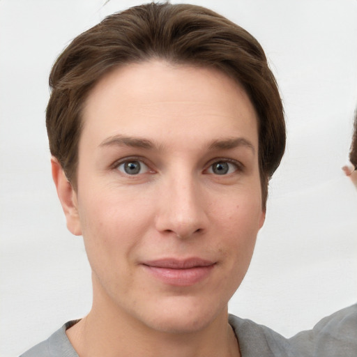 Joyful white young-adult female with short  brown hair and grey eyes