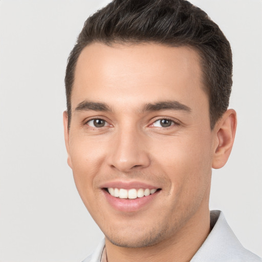 Joyful white young-adult male with short  brown hair and brown eyes