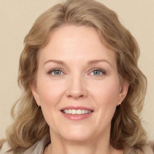 Joyful white adult female with long  brown hair and green eyes