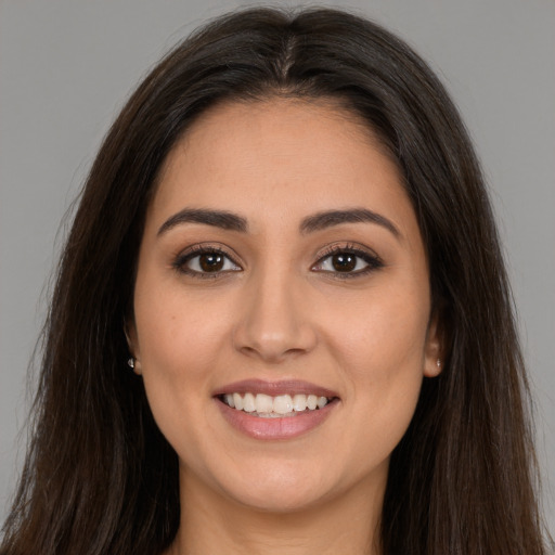 Joyful white young-adult female with long  brown hair and brown eyes