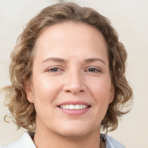 Joyful white young-adult female with medium  brown hair and blue eyes