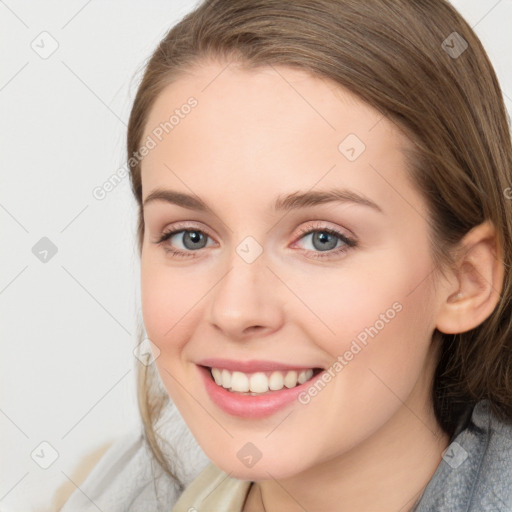 Joyful white young-adult female with medium  brown hair and blue eyes