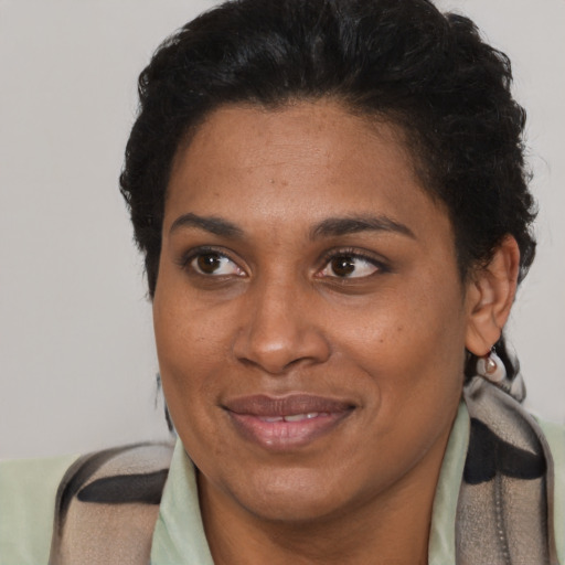 Joyful black adult female with short  brown hair and brown eyes