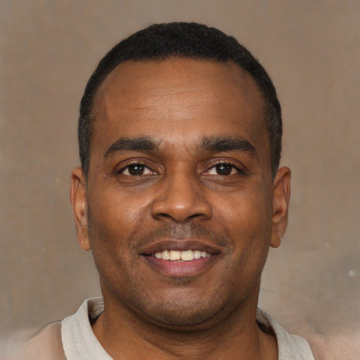 Joyful black young-adult male with short  black hair and brown eyes