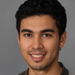 Joyful latino young-adult male with short  brown hair and brown eyes