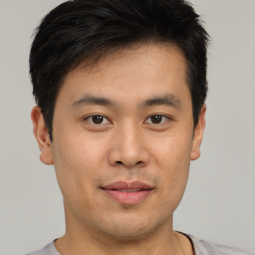 Joyful asian young-adult male with short  brown hair and brown eyes