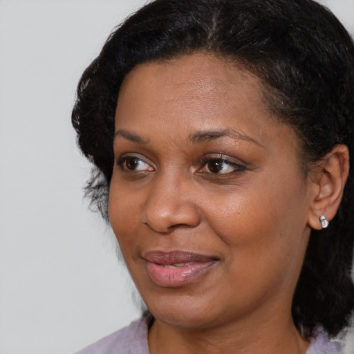 Joyful black adult female with medium  brown hair and brown eyes
