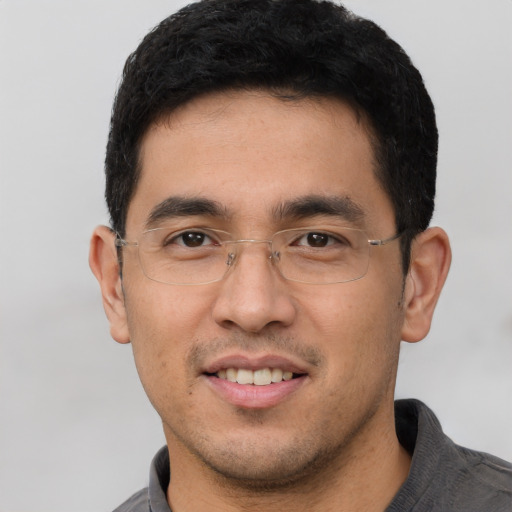 Joyful asian young-adult male with short  black hair and brown eyes