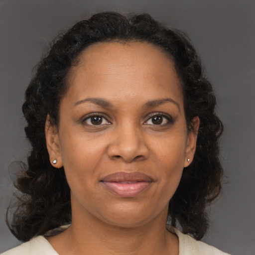 Joyful black adult female with medium  brown hair and brown eyes