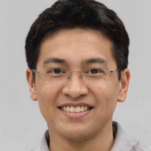 Joyful asian young-adult male with short  brown hair and brown eyes