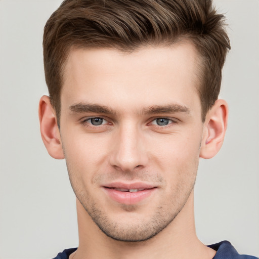 Joyful white young-adult male with short  brown hair and grey eyes