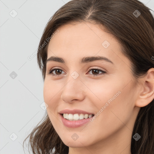 Joyful white young-adult female with long  brown hair and brown eyes