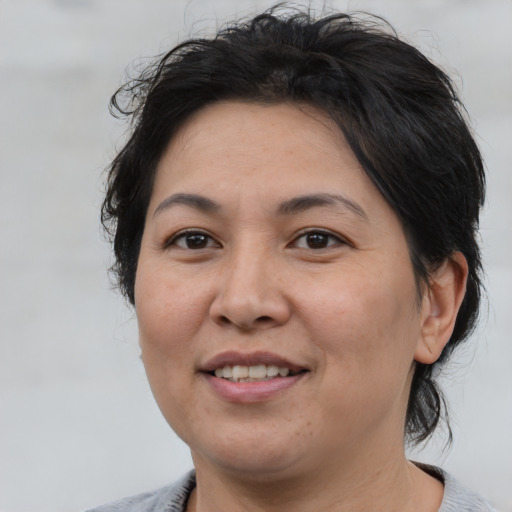 Joyful asian adult female with medium  brown hair and brown eyes