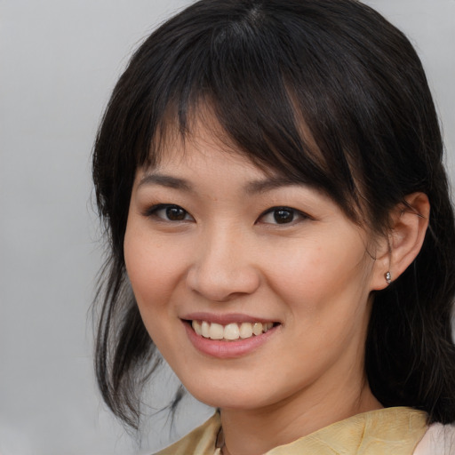 Joyful asian young-adult female with medium  brown hair and brown eyes