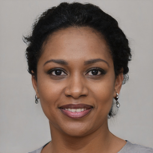 Joyful black young-adult female with short  black hair and brown eyes