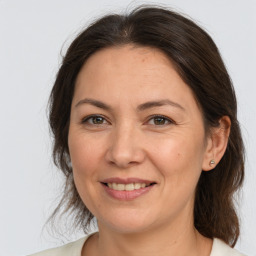 Joyful white adult female with medium  brown hair and brown eyes