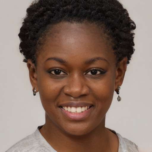 Joyful black young-adult female with short  brown hair and brown eyes