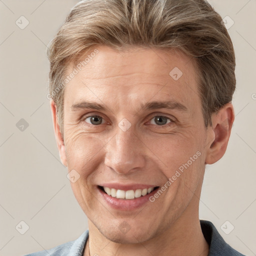 Joyful white adult male with short  brown hair and grey eyes