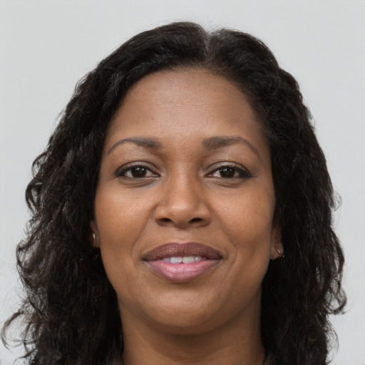 Joyful black adult female with long  brown hair and brown eyes