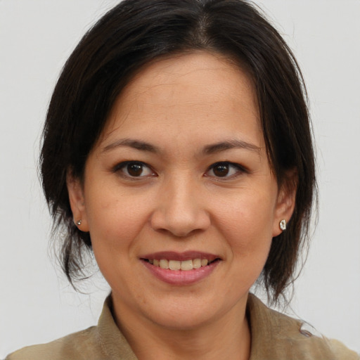 Joyful asian adult female with medium  brown hair and brown eyes