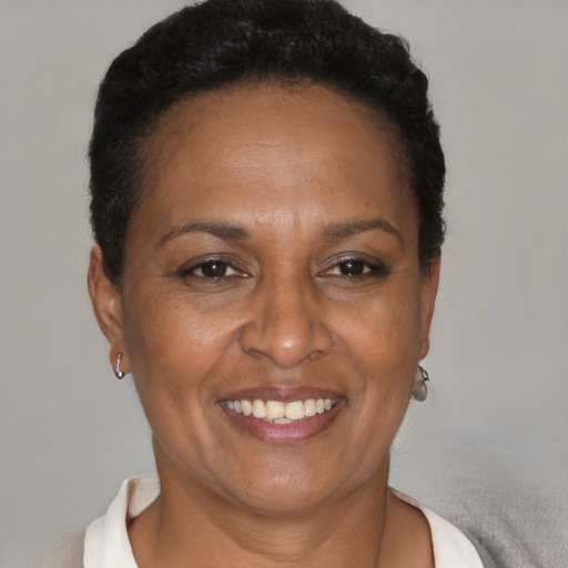 Joyful black adult female with short  brown hair and brown eyes