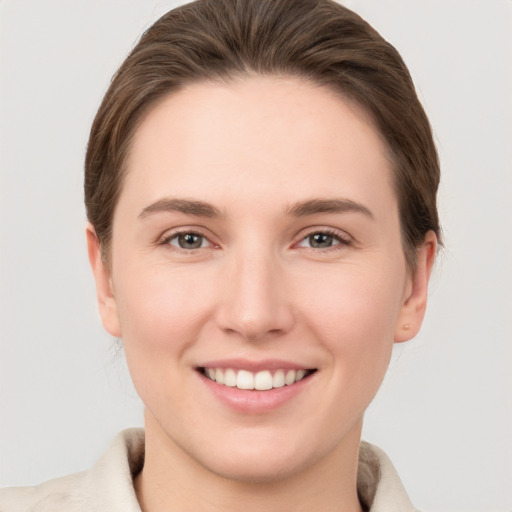 Joyful white young-adult female with short  brown hair and grey eyes