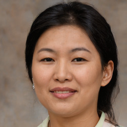 Joyful asian adult female with medium  brown hair and brown eyes